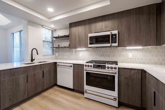 A modern kitchen with a white oven and microwave above it.