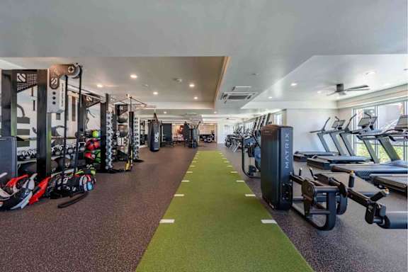 A gym with a variety of equipment including treadmills, weights, and exercise machines.