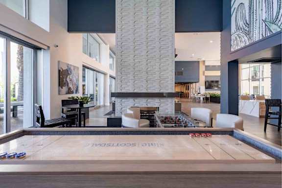 A modern interior space with a large wooden floor and a glass wall.
