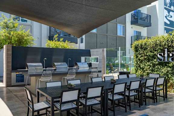 A black table with white chairs is set up outside.