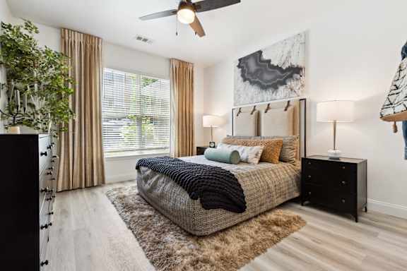 A bedroom with a bed, a ceiling fan, and a rug.