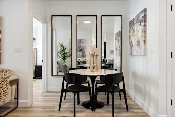 A dining room with a table and chairs.