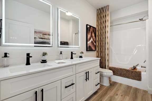 A bathroom with a white sink and a white toilet.