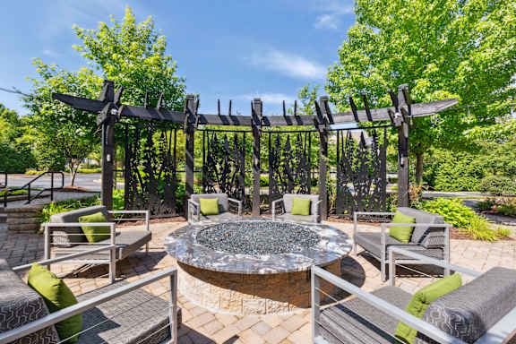 A patio with a fire pit and seating area.