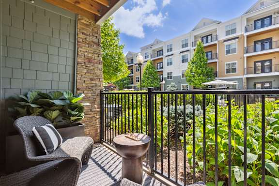 A balcony with a chair and table in front of a building.
