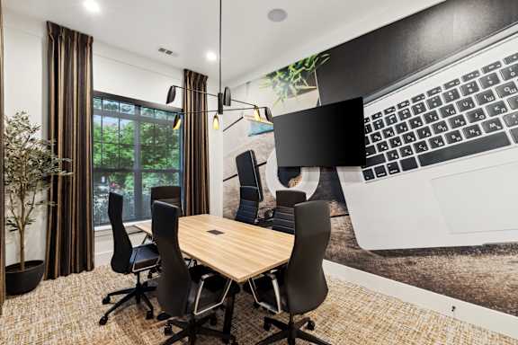 A conference room with a large table and chairs.