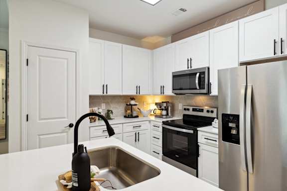 A kitchen with white cabinets and stainless steel appliances.