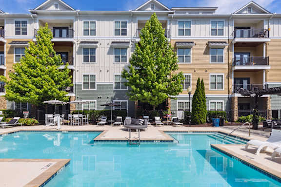 A large swimming pool in front of apartment buildings.