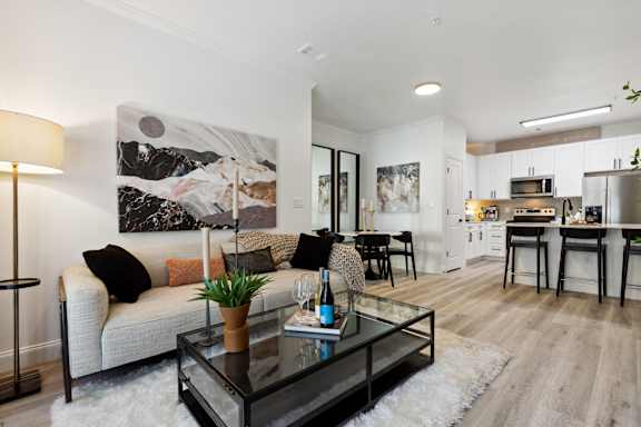A modern living room with a couch, coffee table, and a painting on the wall.
