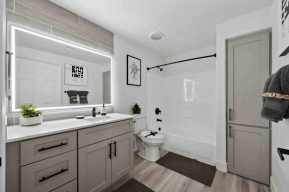 A bathroom with a toilet, sink, and mirror.