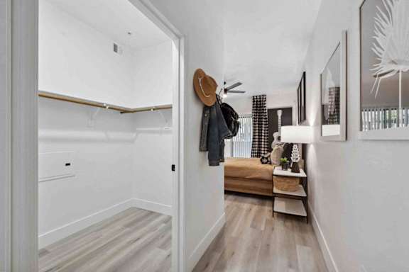 A hallway with a coat rack and a bench.