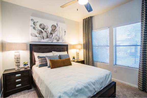 A bedroom with a large bed and a painting on the wall.