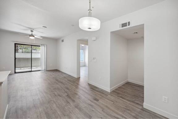 A spacious room with a ceiling fan and sliding glass doors.