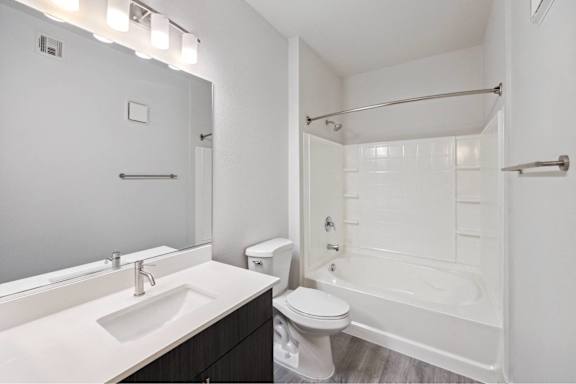 A white bathroom with a sink, toilet, and bathtub.
