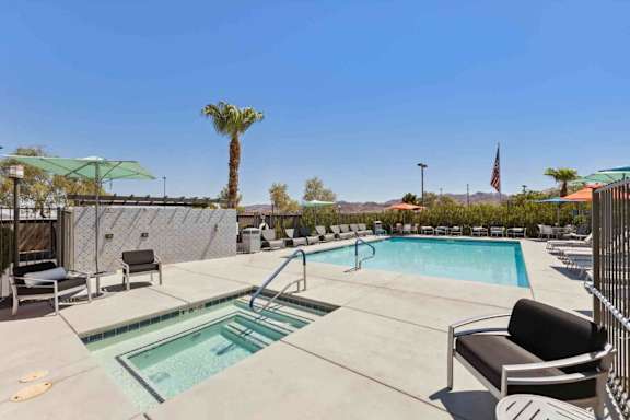A pool with a slide and a palm tree in the background.