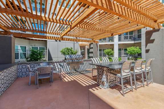 a patio with a table and chairs and a pergola