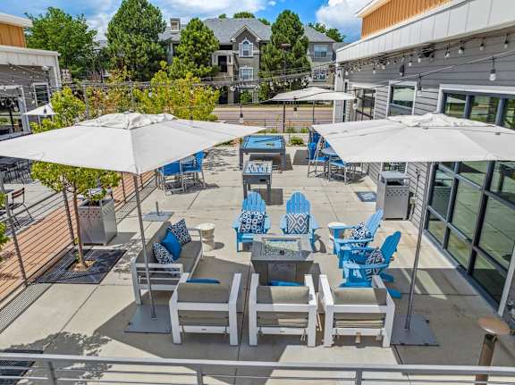 a patio with blue and white chairs and umbrellas