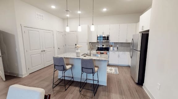 A kitchen with a table and chairs in the middle of the room.