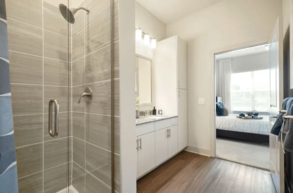 a bathroom with a shower and a bedroom with a bed