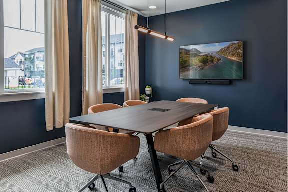 A conference room with a large table and chairs.