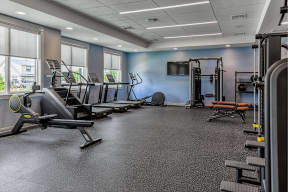 A gym with treadmills, weights, and exercise equipment.