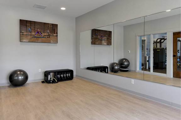 A gym with a mirror, exercise balls, and weights.