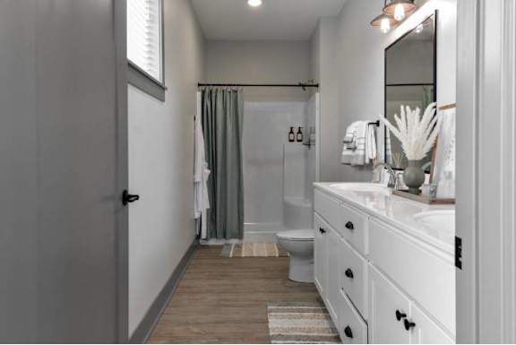 A bathroom with a toilet, sink, and shower.