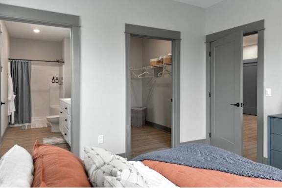 A bedroom with a bed, dresser, and wardrobe.