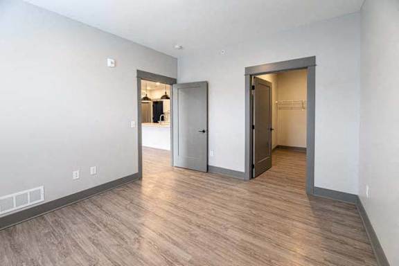 A room with a wooden floor and two doors.