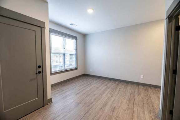 A room with a wooden floor and a large window.