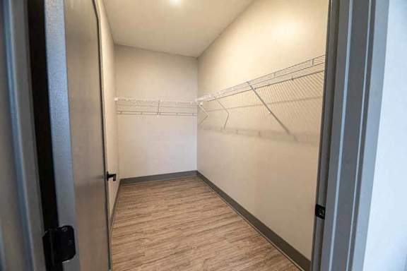 A hallway with a wooden floor and a metal railing.