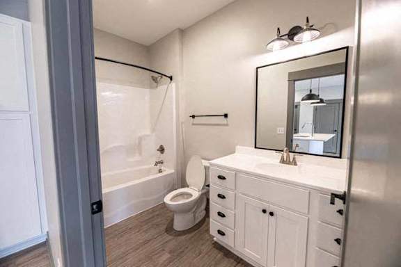 A white bathroom with a toilet, sink, and mirror.