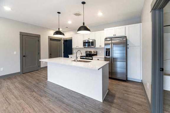A modern kitchen with a white island and stainless steel appliances.