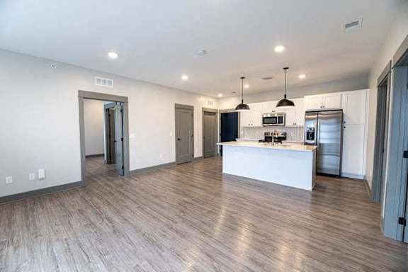 A spacious kitchen with a white countertop and wooden flooring.