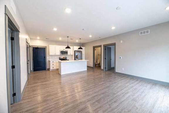 A spacious kitchen with a dining area and a living room.