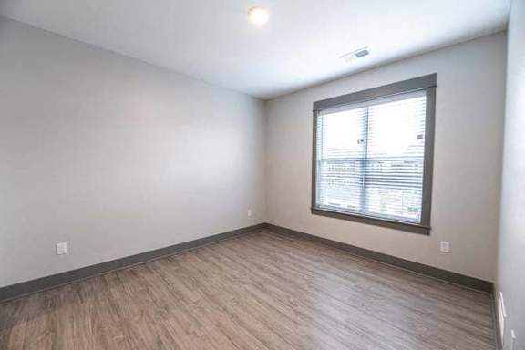 A room with a window and wooden flooring.
