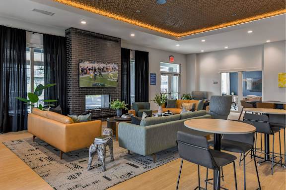 A living room with a large painting of a football game on the wall.