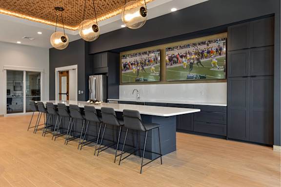 A modern kitchen with a long table and chairs.