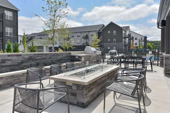 A patio with a table and chairs overlooking a pool.