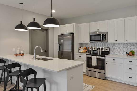 A modern kitchen with white cabinets and a central island.