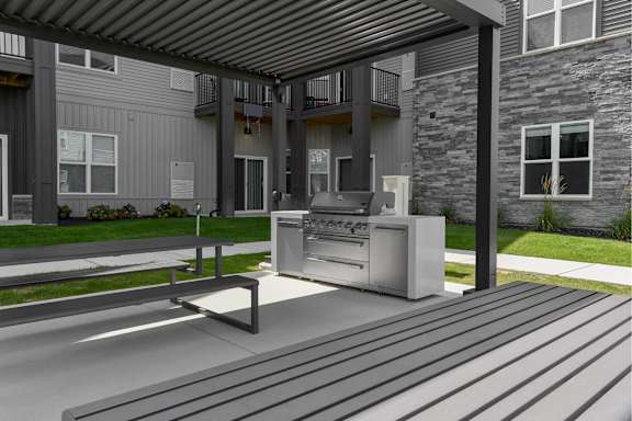 A modern outdoor kitchen area with a grill and sink.