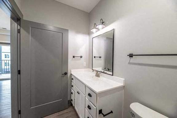 A white bathroom with a sink, mirror, and bathtub.