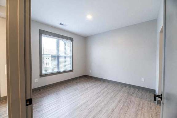 A room with a window and wooden flooring.