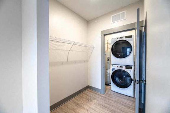 A white washing machine is in a small laundry room.