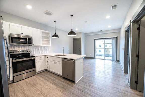 A modern kitchen with stainless steel appliances and white cabinets.