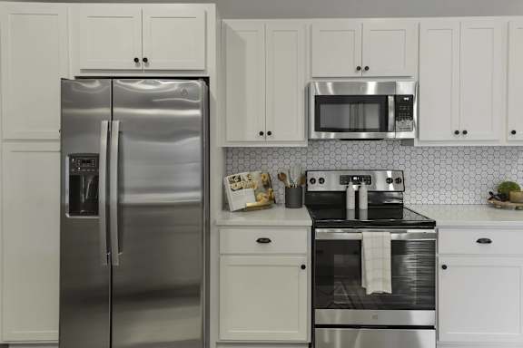 A kitchen with a stainless steel refrigerator and oven.