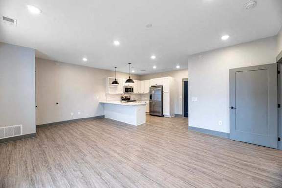 A spacious room with a kitchenette and a bar area.