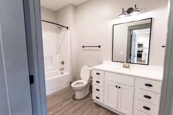 A white bathroom with a toilet, sink, and mirror.
