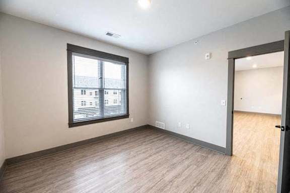 A room with a window and wooden flooring.