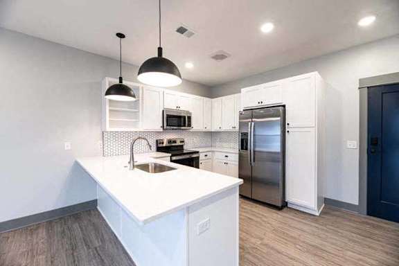 A modern kitchen with white cabinets and a center island.